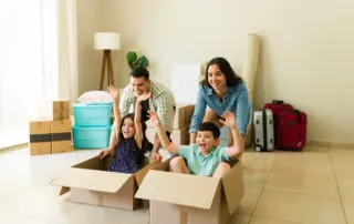 Happy family of four having fun and playing games while moving together into their new house