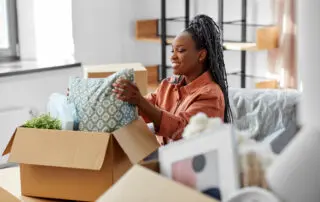 happy woman unpacking boxes with stuff at new home