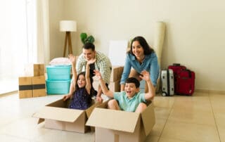 Happy family of four having fun and playing games while moving together into their new house