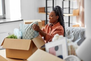 happy woman unpacking boxes with stuff at new home