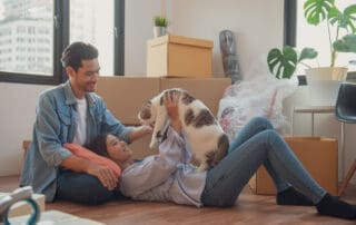 Young couple or family feeling happy relaxing and play with their cat after moving to new house or apartment.