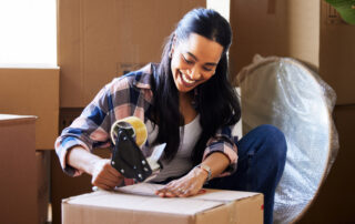 woman packing a moving essentials box